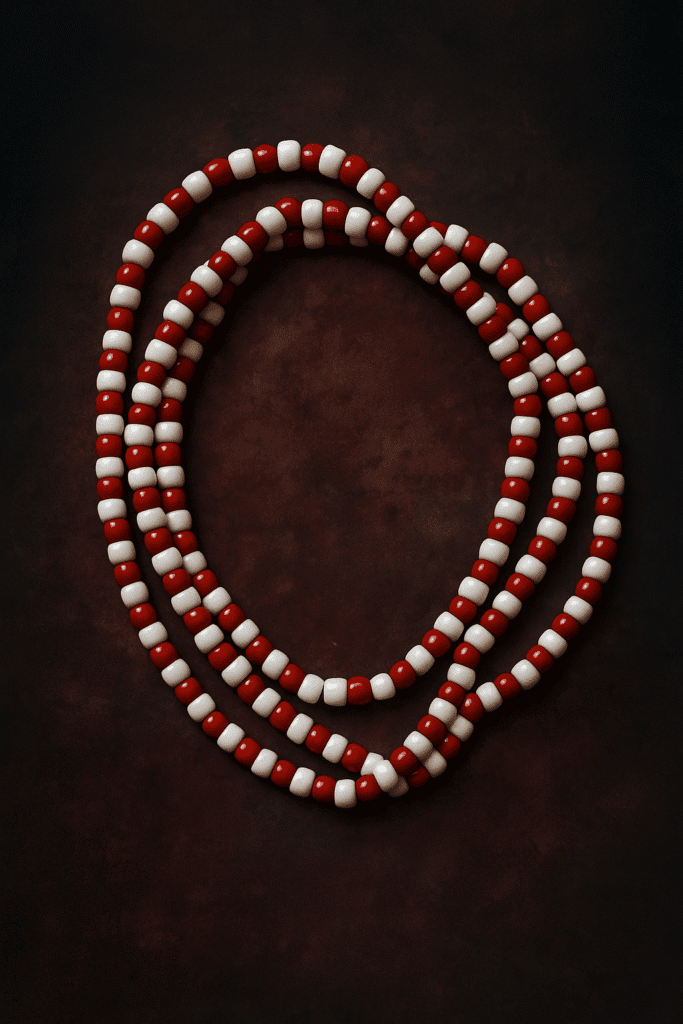 Beaded necklace rossi e bianchi su sfondo scuro, oggetto misterioso e affascinante.